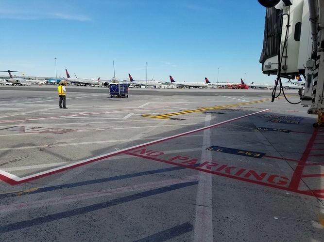 A man standing on the tarmac of an airport.