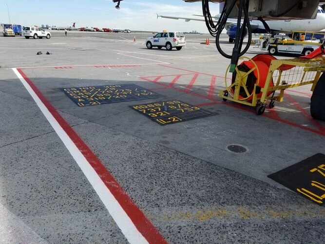 A plane on the tarmac with a truck in front of it.