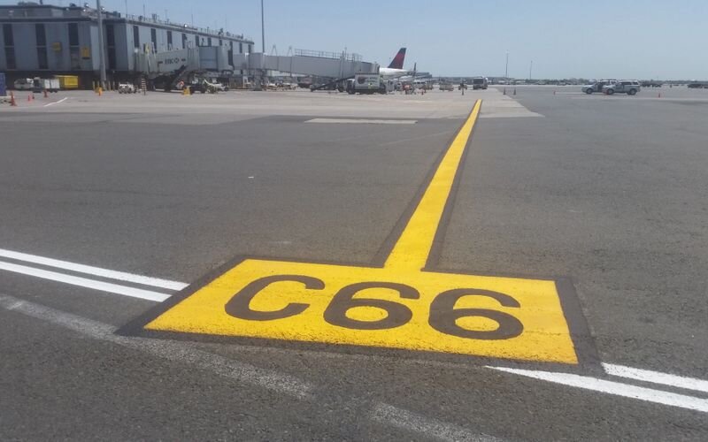 A yellow sign on the ground with " c 6 6 " written in it.