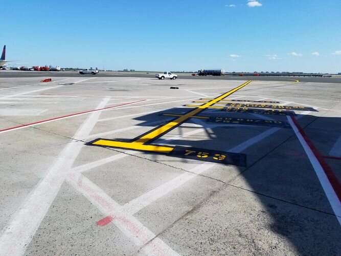 A runway with yellow lines and white markings.