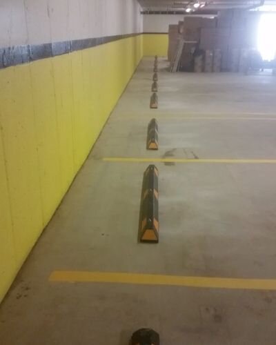 A parking lot with yellow walls and black lines.