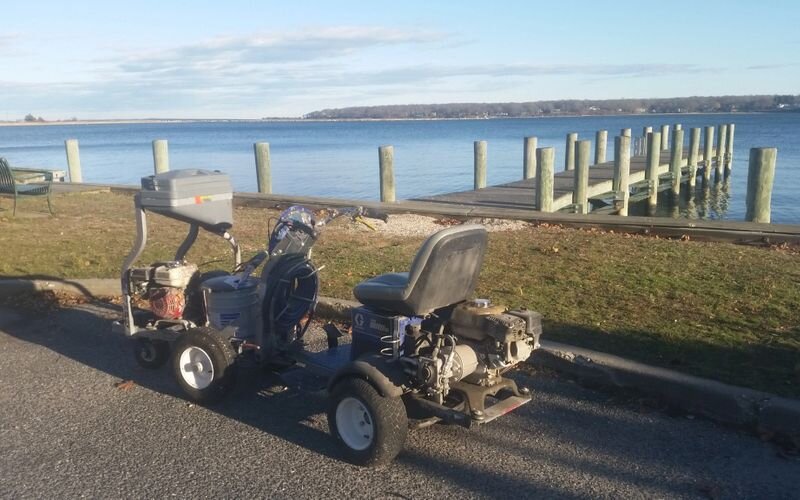 A couple of lawn mowers parked on the side of a road.