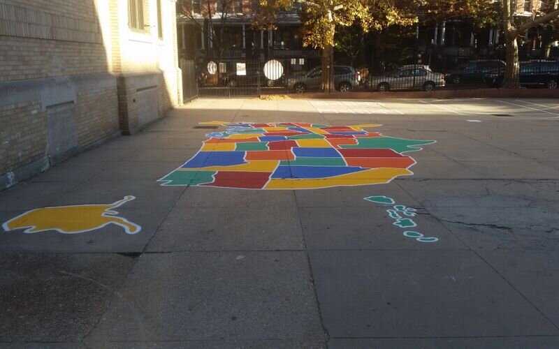 A sidewalk with colorful squares and a map of the city.