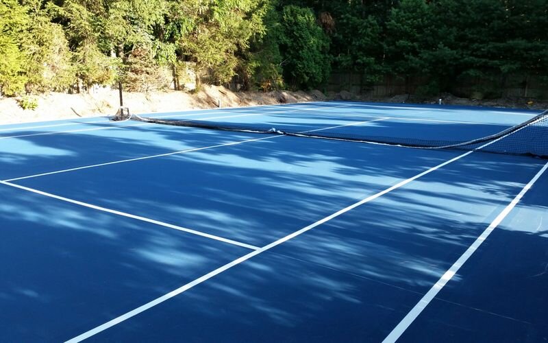 A tennis court with trees in the background.