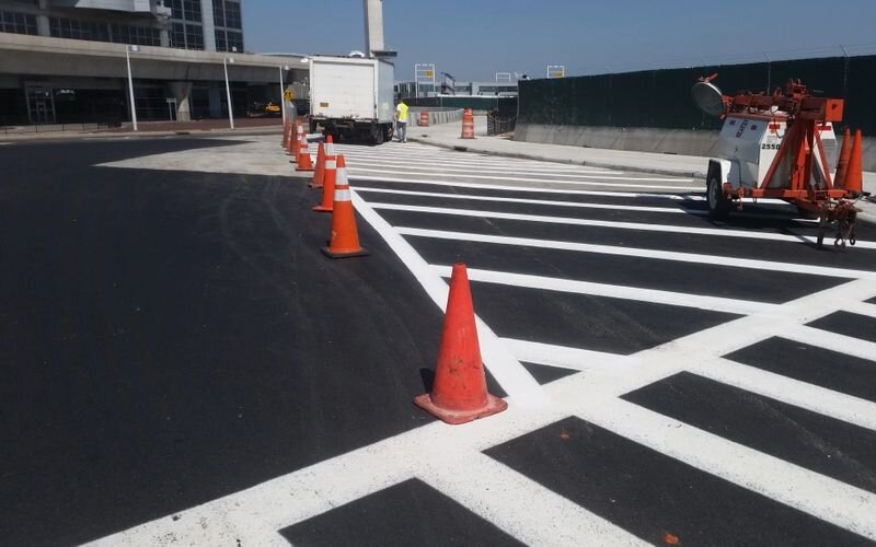 A street with orange cones on the side of it.