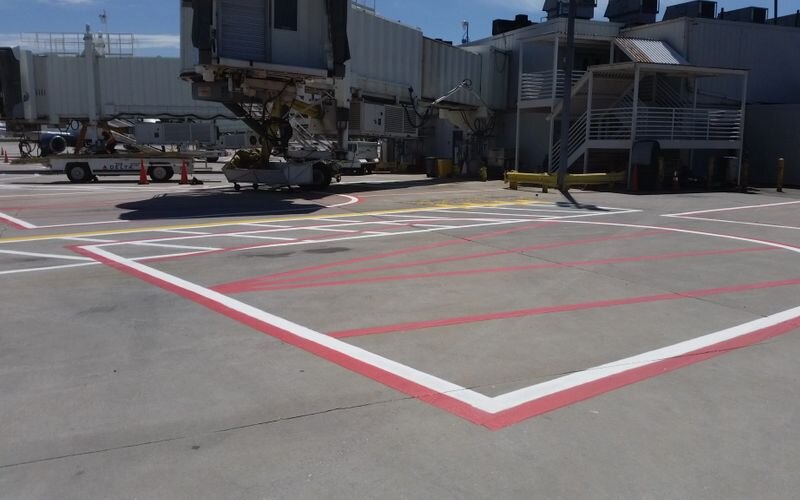 A large truck parked in an airport parking lot.