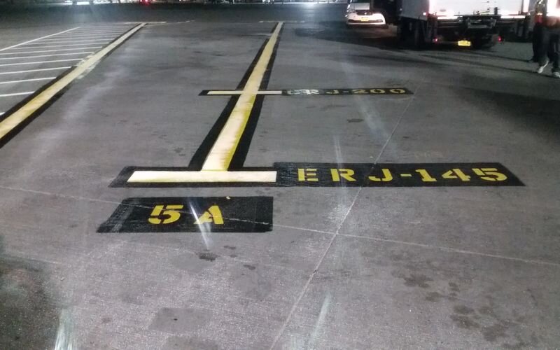 A parking lot with yellow and black markings.