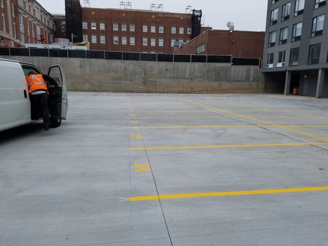 A man driving a vehicle in an empty parking lot.