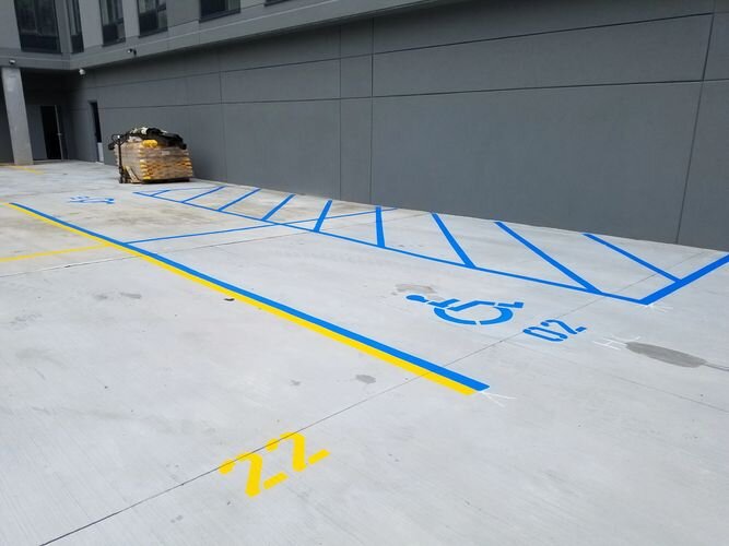 A parking lot with yellow and blue lines painted on it.