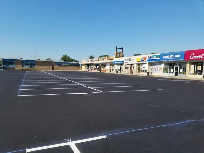 A parking lot with many different stores in the background.