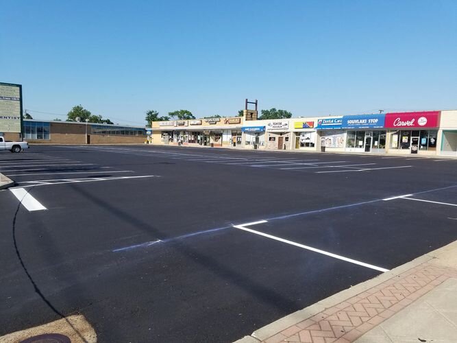 A parking lot with many cars parked on the side of it.