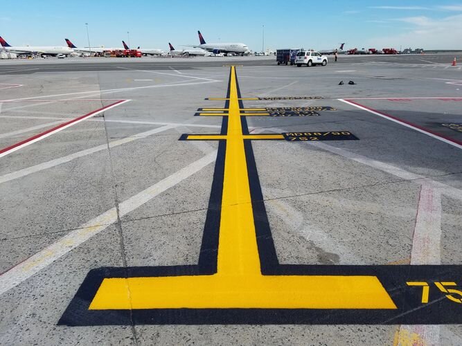 A runway with yellow lines painted on it.