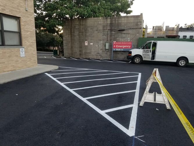 A white van parked in the middle of an empty parking lot.