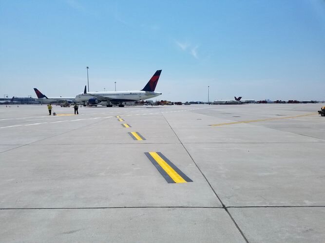 A plane is sitting on the tarmac at an airport.