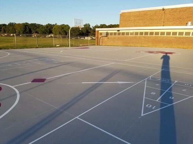 A basketball court with a basketball hoop and a building.