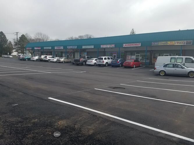 A parking lot with cars parked in front of it.