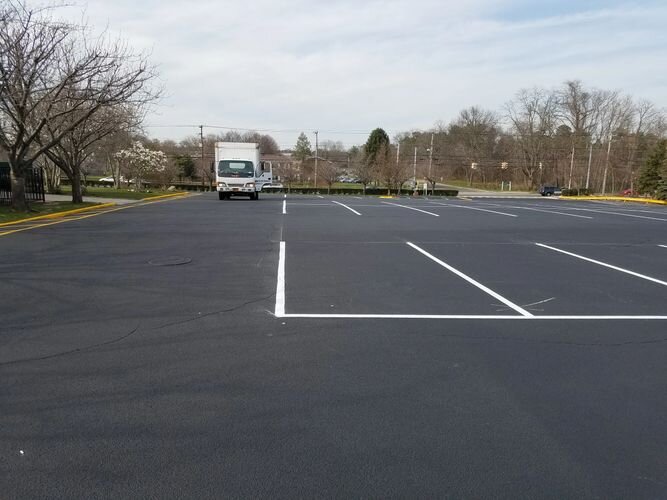 A truck is parked in the middle of an empty parking lot.