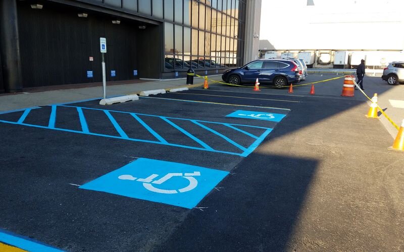 A parking lot with blue lines and handicapped signs.