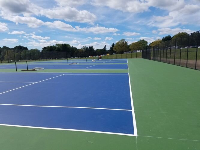 A tennis court with two different colors of blue and one green.