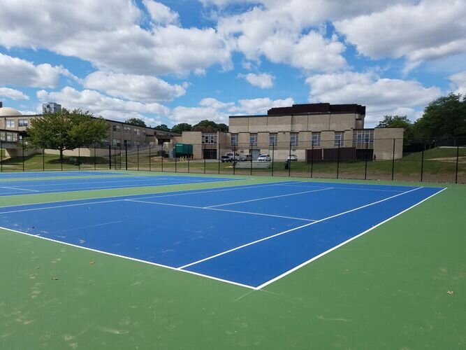 A tennis court with two blue and one green.