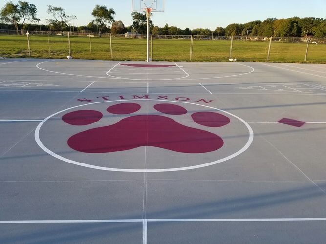 A basketball court with a red paw print painted on it.