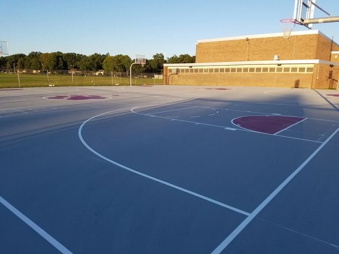 A basketball court with a red and white stripe on the side.