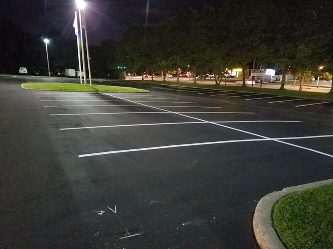 A parking lot at night with lights on.