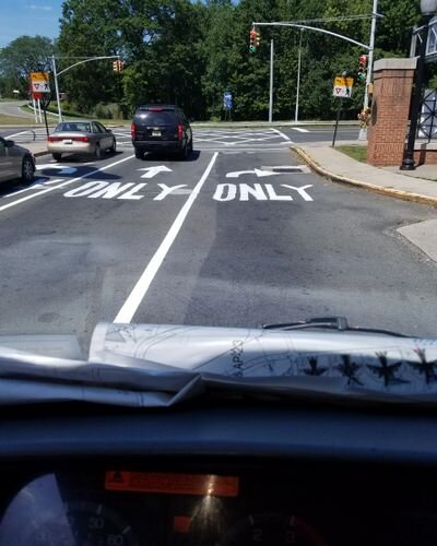 A view of cars driving down the street from inside a car.