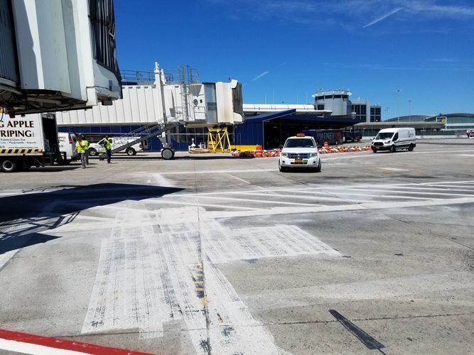 A car is parked in an airport lot.